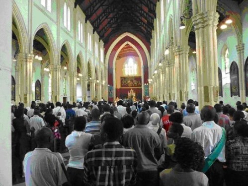 Catholics standing at Holy Mass